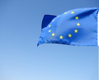 Waving European Union Flag On The Blue Background